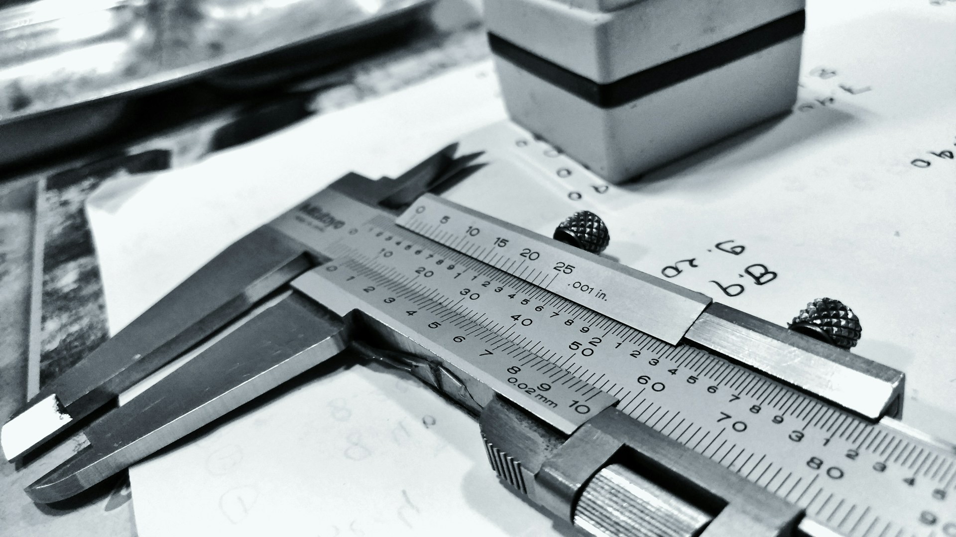 A gray dial caliper used for precision measurement