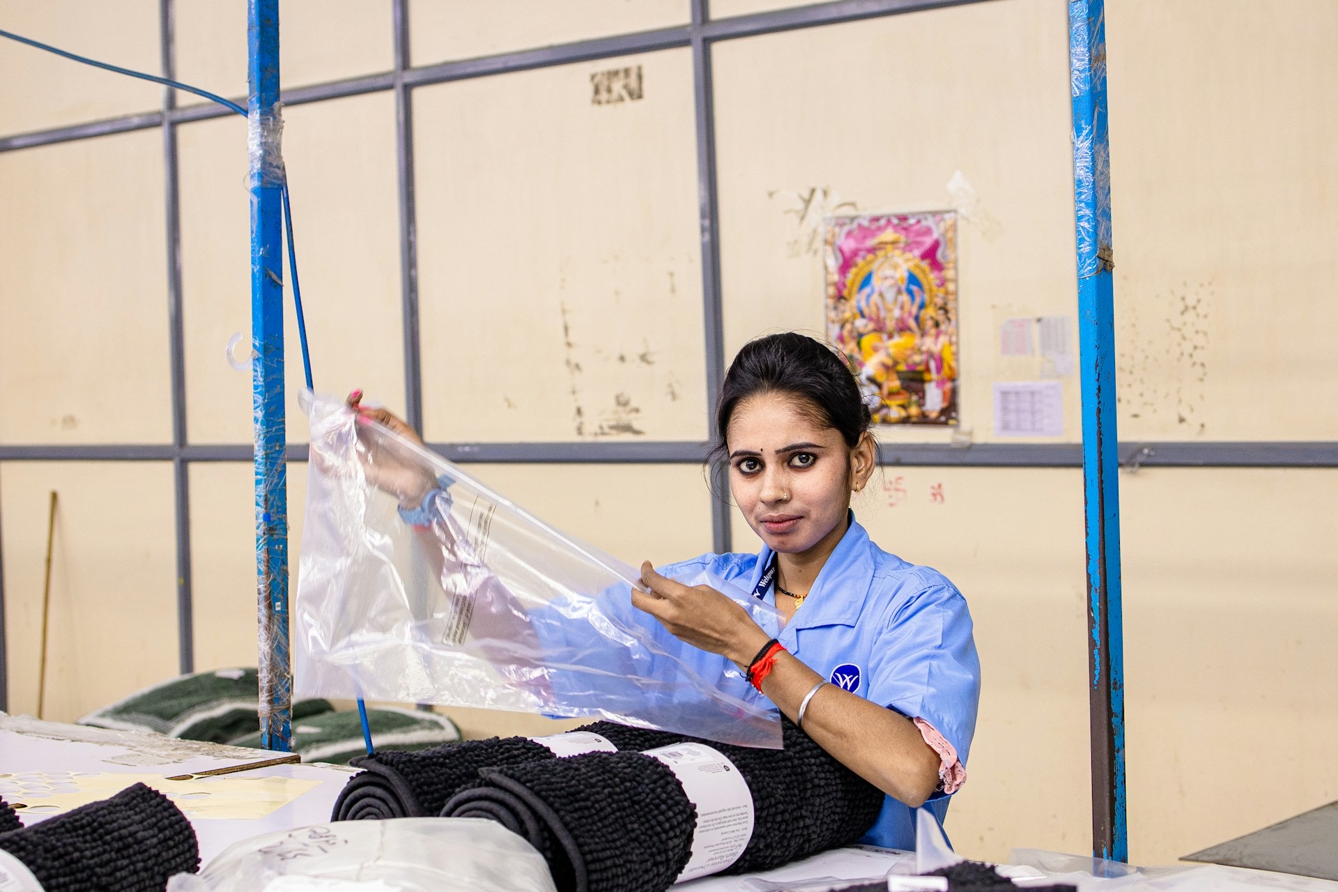 A woman packaging a product at a workbench