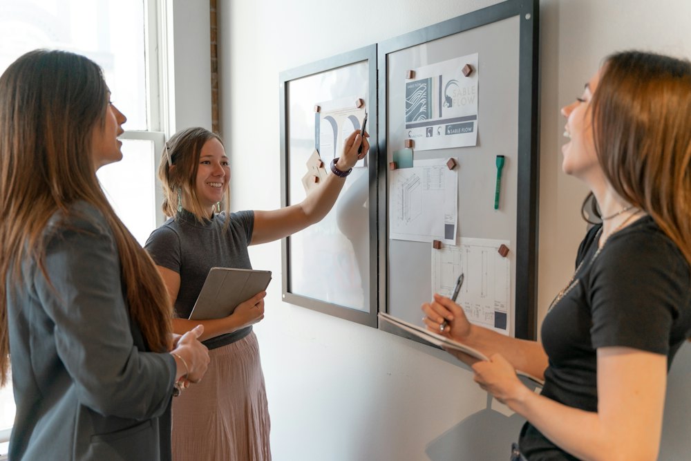 A woman talking through two ordered boards on a wall