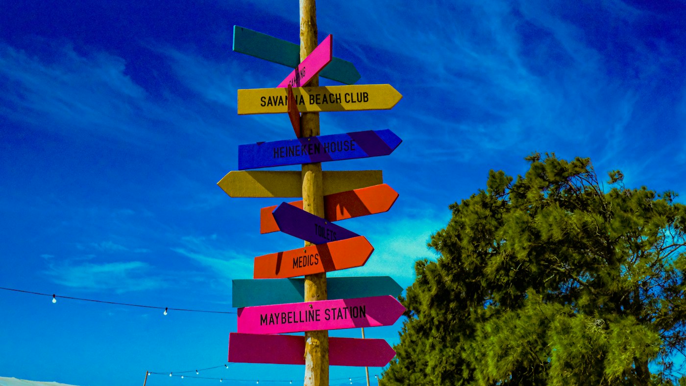 A post crowded with signs pointing in every direction