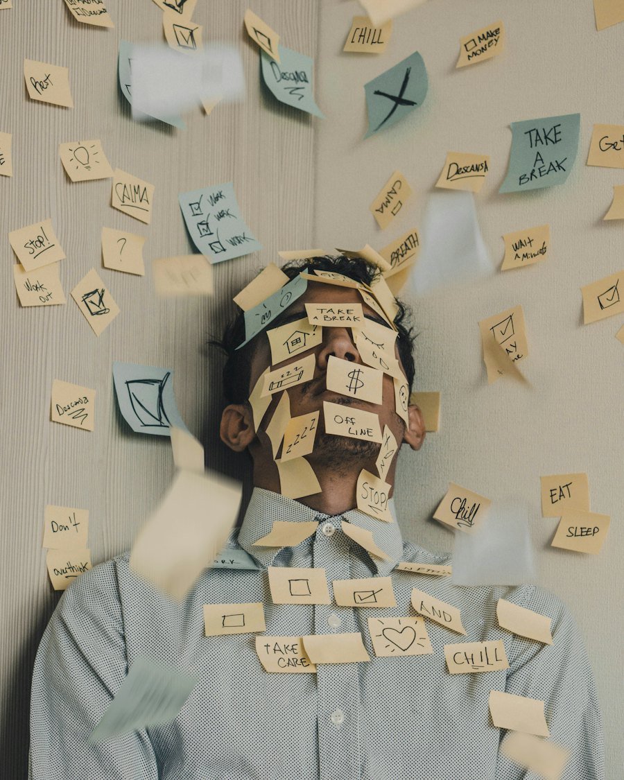 A man at his desk, his face hidden under a layer of sticky notes