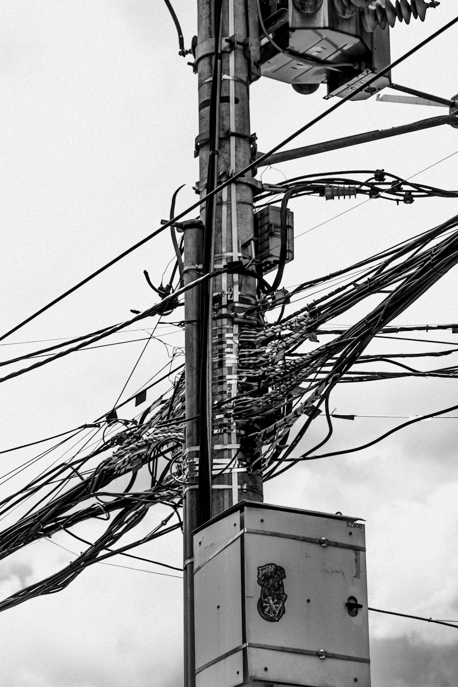 A utility pole knotted with tangled cables